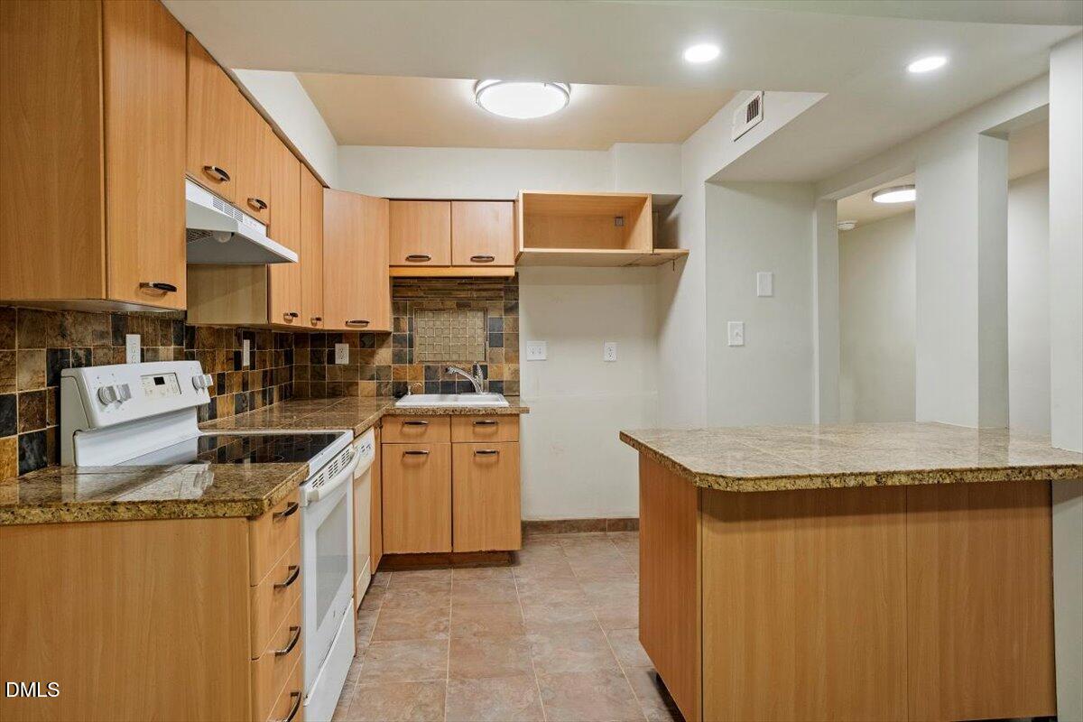 7124 Longstreet Drive, Unit C Raleigh, NC 27615 - Photo 11 of 27 a kitchen with stainless steel appliances granite countertop a sink and a refrigerator