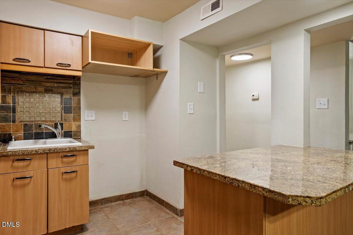 7124 Longstreet Drive, Unit C Raleigh, NC 27615 - Photo 13 of 27 a bathroom with a granite countertop sink and washing machine