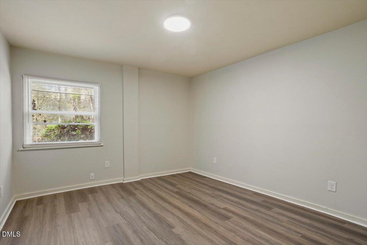 7124 Longstreet Drive, Unit C Raleigh, NC 27615 - Photo 20 of 27 an empty room with wooden floor and windows