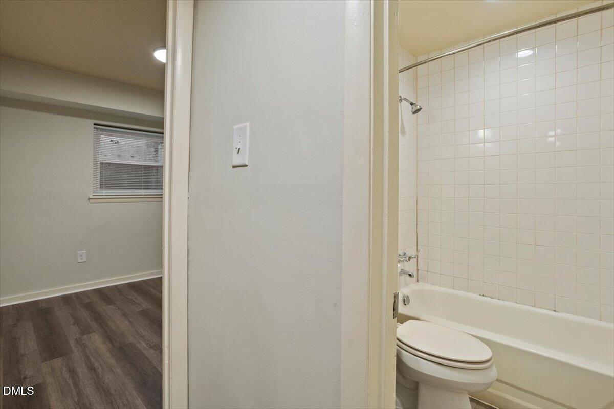 7124 Longstreet Drive, Unit C Raleigh, NC 27615 - Photo 23 of 27 a bathroom with a granite countertop toilet a sink and shower