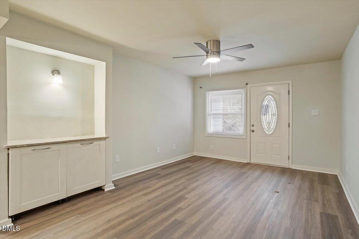 7124 Longstreet Drive, Unit C Raleigh, NC 27615 - Photo 6 of 27 a view of an empty room with wooden floor and a window