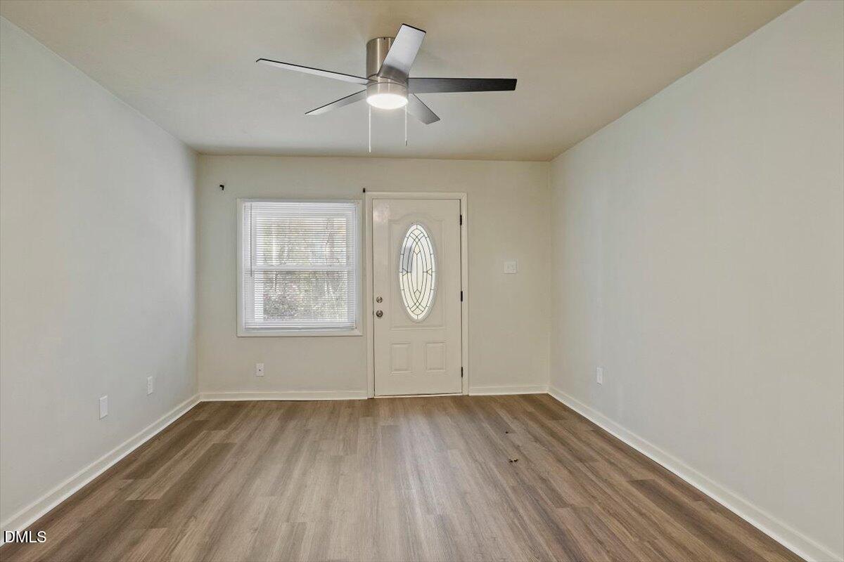 7124 Longstreet Drive, Unit C Raleigh, NC 27615 - Photo 7 of 27 an empty room with wooden floor fan and windows