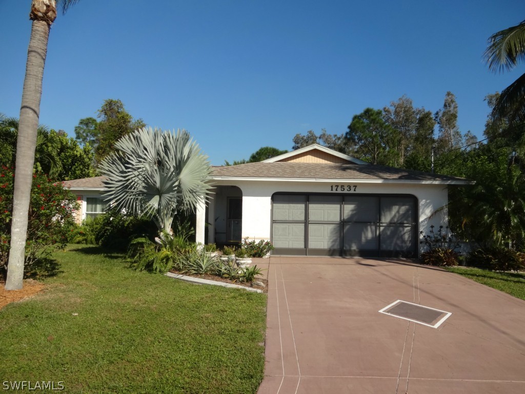 17537 Laurel Valley Road Fort Myers, FL 33967 - Photo 1 of 16 a front view of a house with a yard and garage