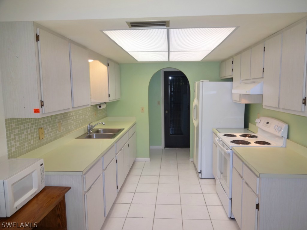 17537 Laurel Valley Road Fort Myers, FL 33967 - Photo 2 of 16 a kitchen with a sink a stove and cabinets