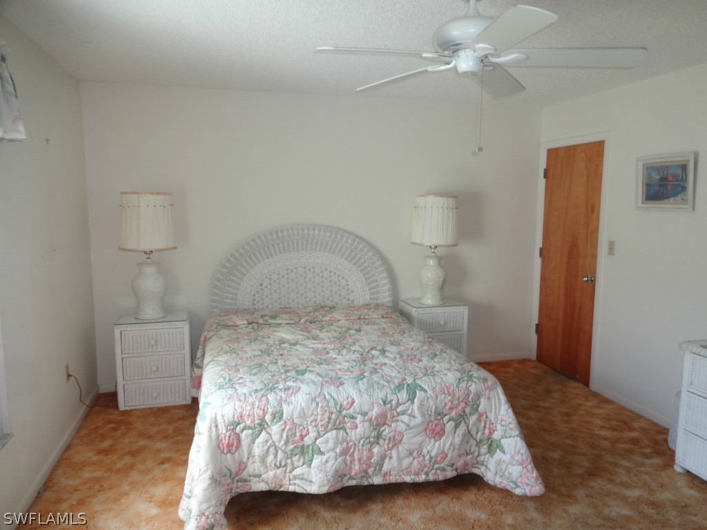 17537 Laurel Valley Road Fort Myers, FL 33967 - Photo 9 of 16 a bedroom with a bed and a chandelier