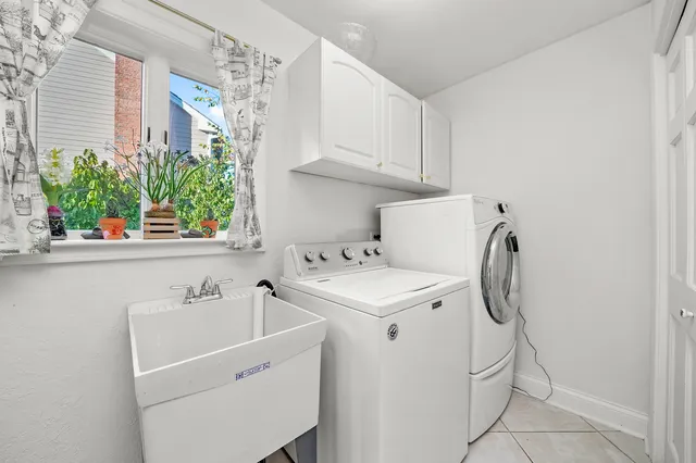 a utility room with cabinets washer and dryer