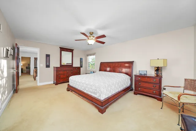 a bedroom with a large bed a chandelier and dresser