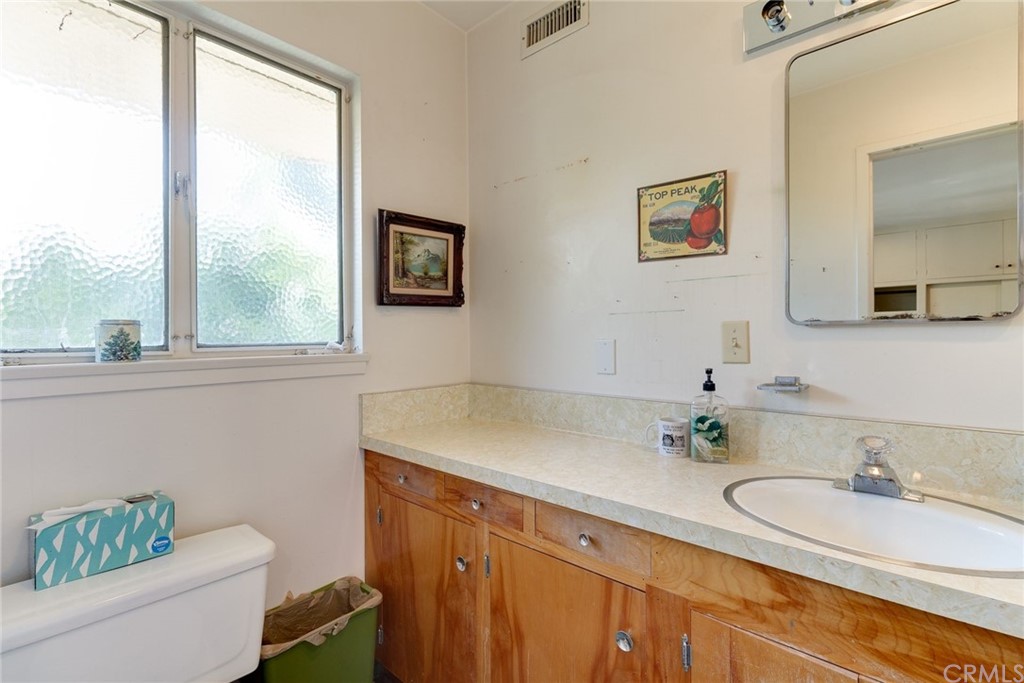 2000 Braeburn Road Altadena, CA 91001 - Photo 29 of 46 a bathroom with a granite countertop sink a toilet a mirror and a window