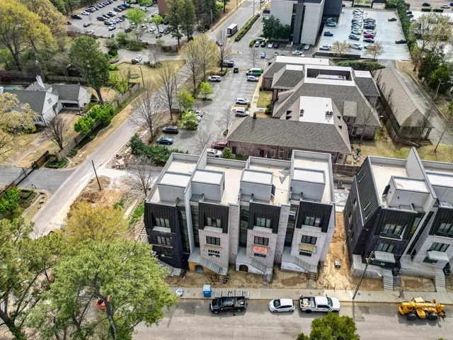 an aerial view of multi story residential apartment building with parking area