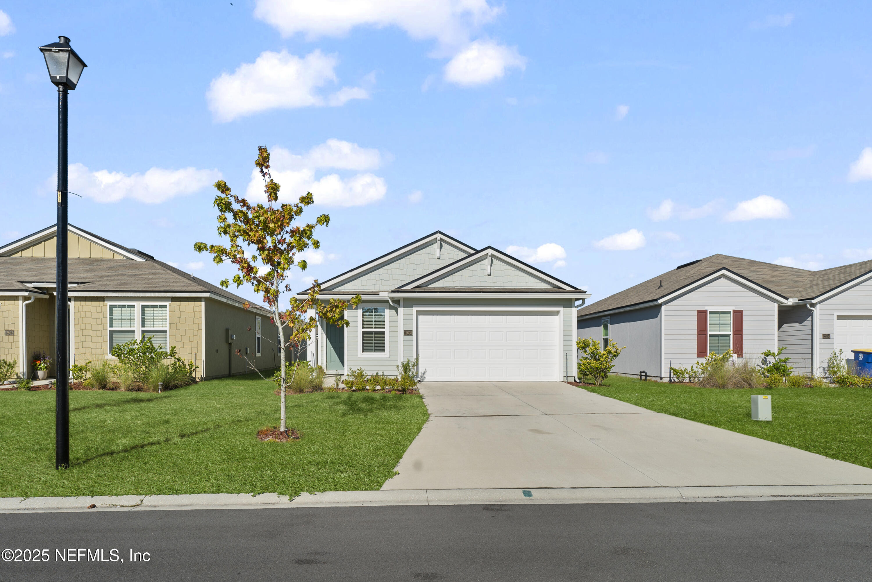 12698 Cucumber Tree Street Jacksonville, FL 32218 - Photo 3 of 26 a front view of a house with a garden and trees