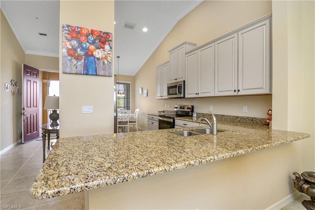 9440 Benvenuto Court, Unit 3204 Naples, FL 34119 - Photo 11 of 28 a kitchen with stainless steel appliances granite countertop a sink refrigerator and cabinets