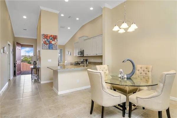 a dining room filled chandelier and kitchen view