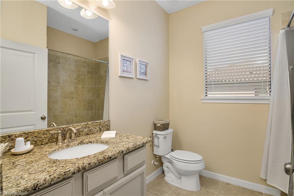9440 Benvenuto Court, Unit 3204 Naples, FL 34119 - Photo 2 of 28 a bathroom with a granite countertop sink toilet and a mirror