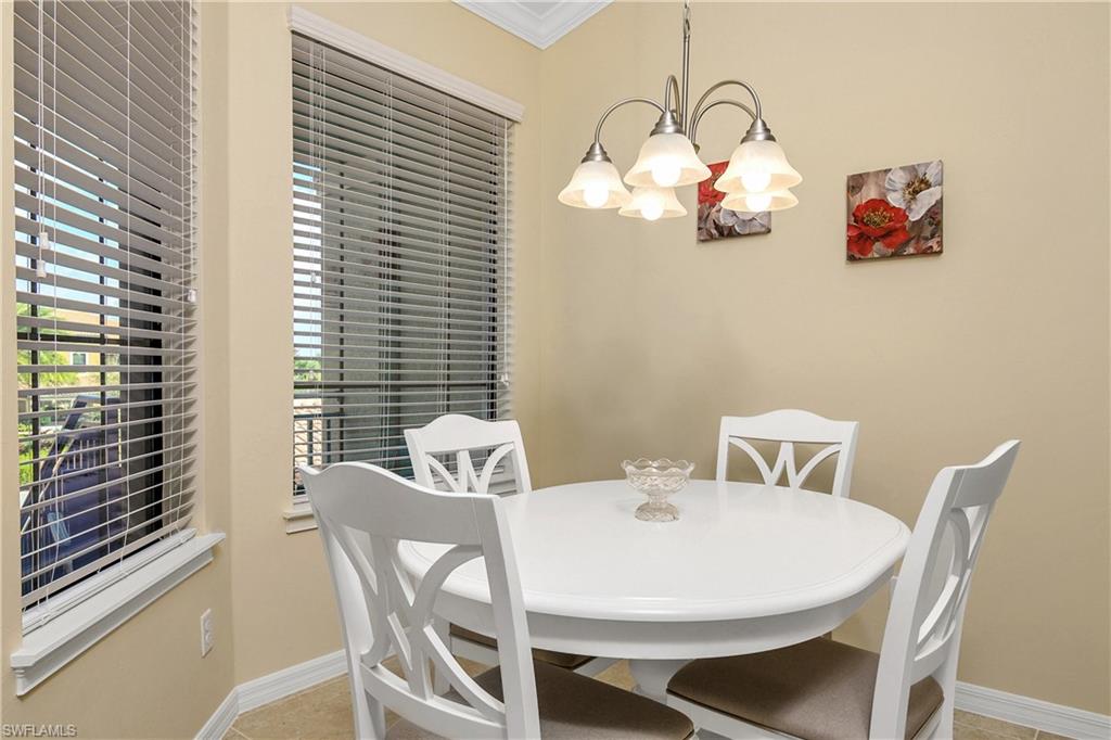 9440 Benvenuto Court, Unit 3204 Naples, FL 34119 - Photo 22 of 28 a view of a dining room with furniture and chandelier