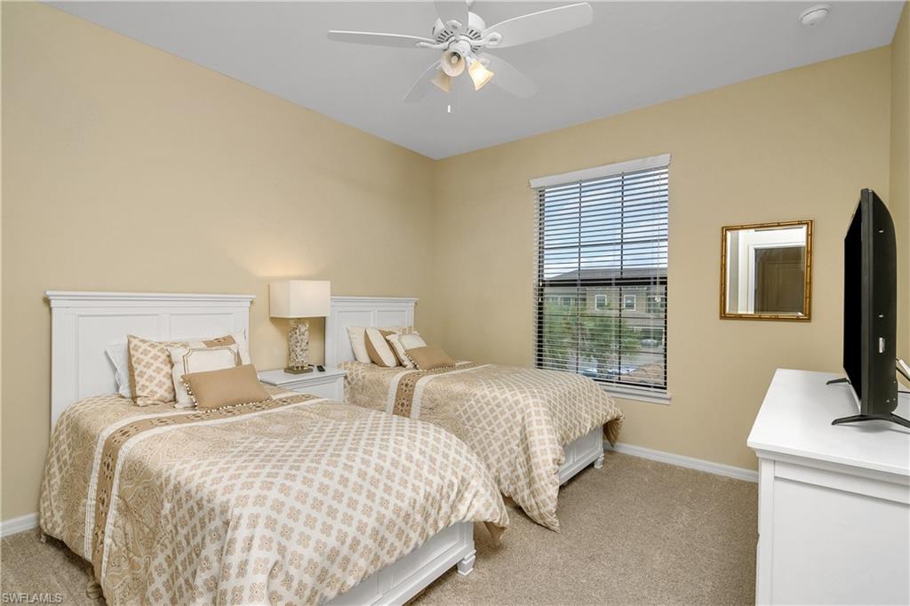 9440 Benvenuto Court, Unit 3204 Naples, FL 34119 - Photo 26 of 28 a bedroom with two beds and a flat screen tv
