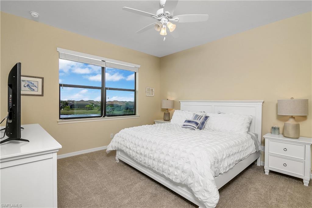 9440 Benvenuto Court, Unit 3204 Naples, FL 34119 - Photo 27 of 28 a bedroom with a large bed and a window