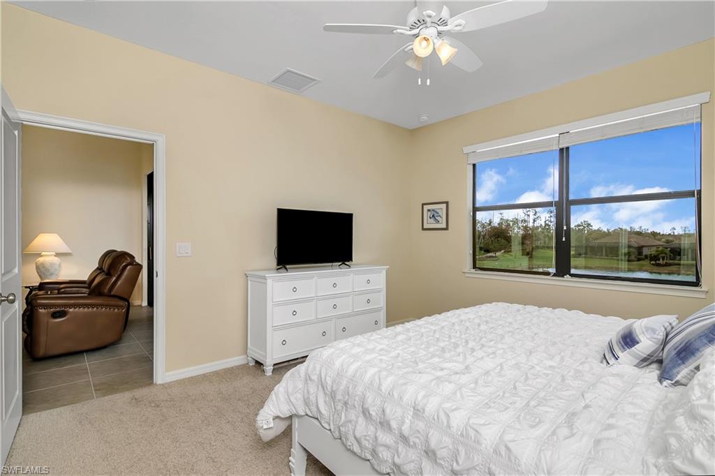 9440 Benvenuto Court, Unit 3204 Naples, FL 34119 - Photo 10 of 28 a bedroom with a bed and a flat screen tv