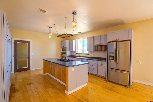 a kitchen with stainless steel appliances granite countertop a stove a refrigerator and a refrigerator