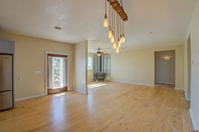 a view of a livingroom with furniture a window and wooden floor