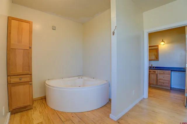 a view of an empty room with chandelier fan and a window