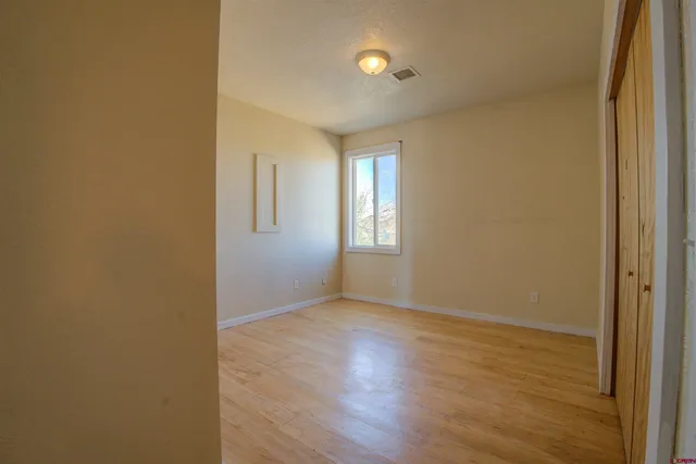 a view of an empty room with wooden floor