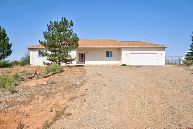 a view of white house with a yard and large tree