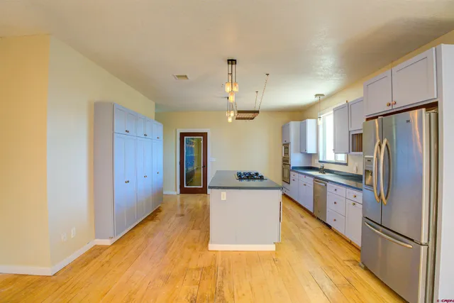 a large kitchen with stainless steel appliances a refrigerator and a stove top oven