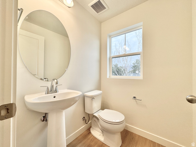 1650 North Main Street Layton, UT 84041 - Photo 10 of 24 Pedestal sink with chrome fixtures, oval mirror, and wood-finish flooring