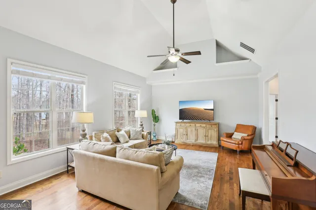 a kitchen with stainless steel appliances granite countertop a kitchen island a stove a refrigerator a oven a sink a dining table and chairs with wooden floor