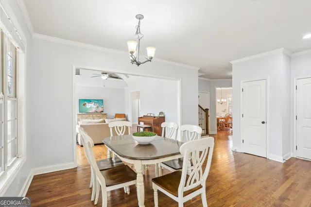 a kitchen with stainless steel appliances granite countertop a stove top oven a sink a dining table and chairs