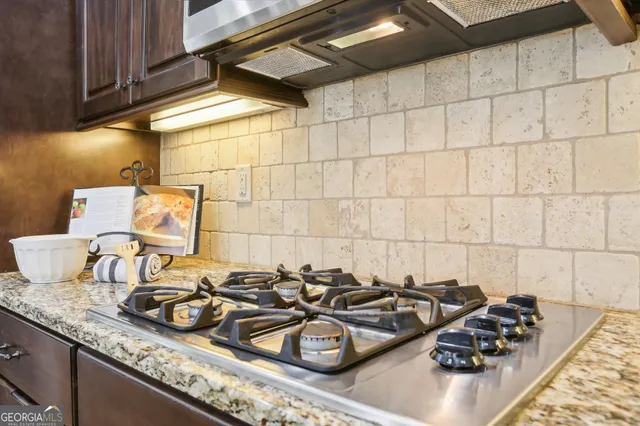 a bedroom with a bed a lamp on the dresser and a chandelier