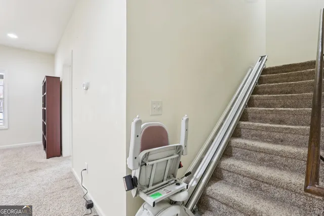 a view of a white house next to a yard with potted plants