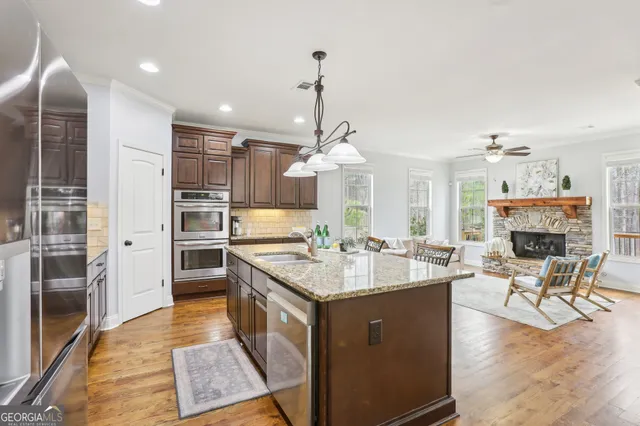a view of a hallway to a livingroom with wooden floor and furniture