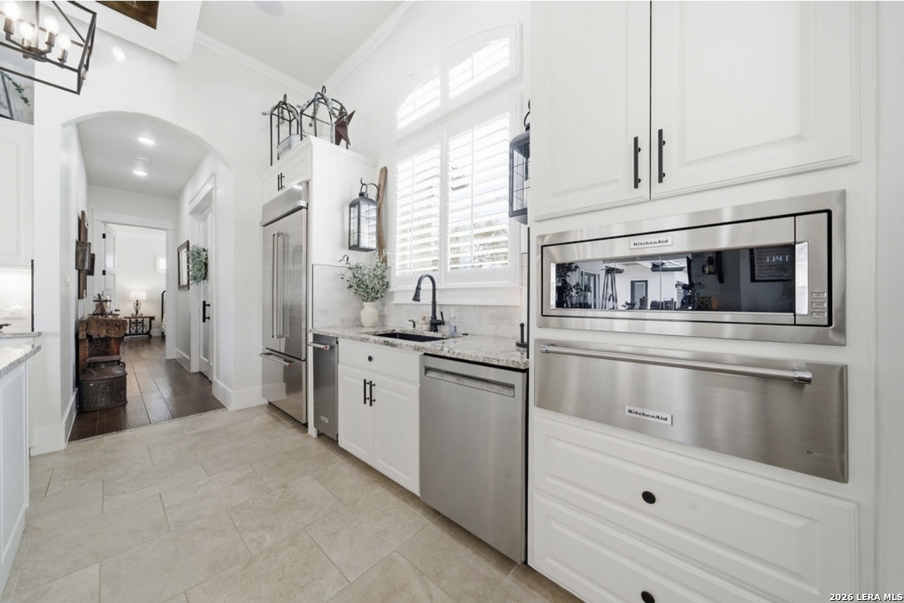 5920 Verden Ridge New Braunfels, TX 78132 - Photo 13 of 61 a kitchen with stainless steel appliances kitchen island a white cabinets and stove top oven