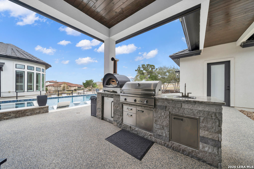 5920 Verden Ridge New Braunfels, TX 78132 - Photo 46 of 61 a kitchen with stainless steel appliances granite countertop a stove a sink and a microwave