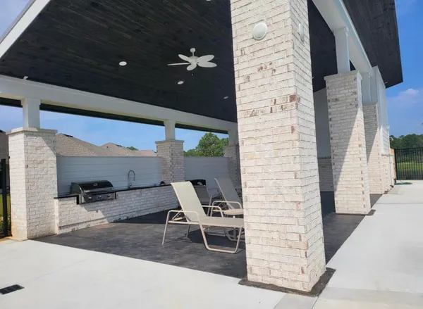 a patio with table and chairs and potted plants