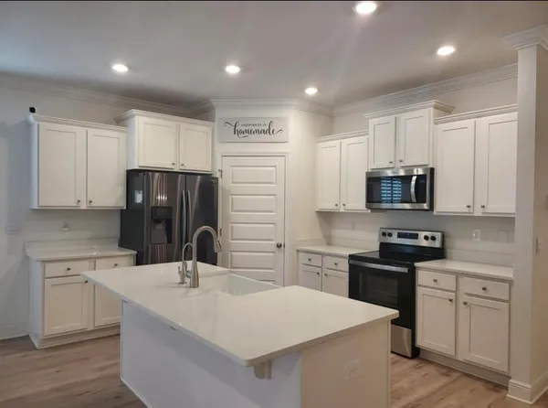 a kitchen with appliances a sink and cabinets
