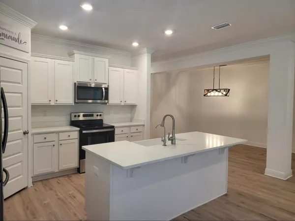 a kitchen with stainless steel appliances a sink a stove a microwave and cabinets