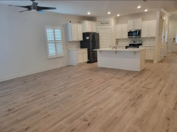 a view of kitchen with stainless steel appliances kitchen island wooden floor and window