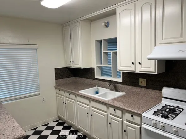 a kitchen with stainless steel appliances a stove a sink and a refrigerator