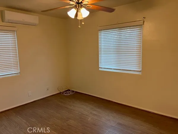 an empty room with a window and a fan