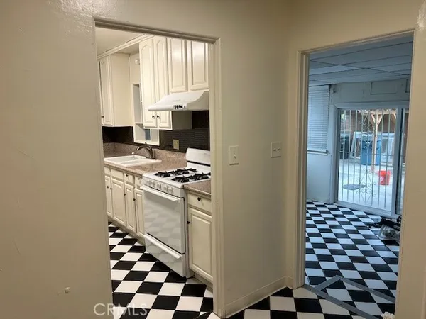 a kitchen with a checkered floor and white cabinets