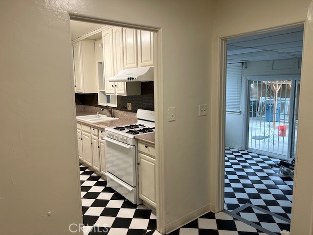 3909 Glen Way El Monte, CA 91731 - Photo 9 of 22 a kitchen with a checkered floor and white cabinets