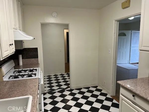 a kitchen with a checkered floor and black white cabinets