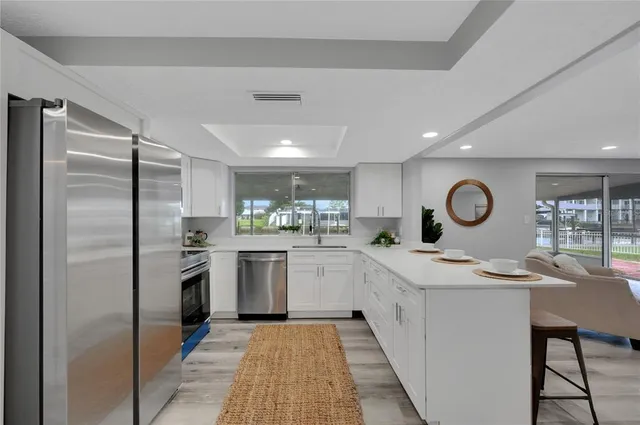 a kitchen with white cabinets and stainless steel appliances