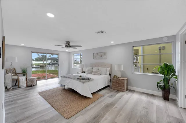a living room with furniture large window and wooden floor