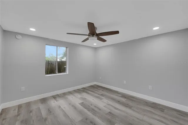 a view of a room with wooden floor and a ceiling fan