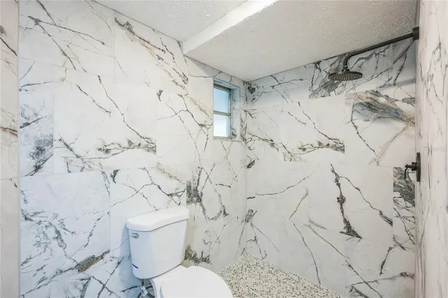 a white toilet sitting next to a shower and a shower curtain