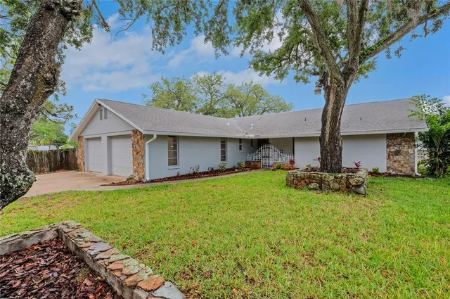 a view of a house with backyard and sitting area