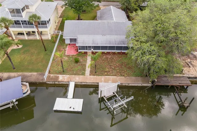 an aerial view of a house with swimming pool and large trees